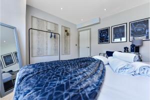 a bedroom with a large bed with a blue comforter at Stylish 2 Bedroom Apartment - Wembley Park in London