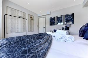 a bedroom with a large bed with blue and white sheets at Stylish 2 Bedroom Apartment - Wembley Park in London