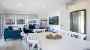 a living room with a white table and chairs at Ettalong Beach House in Ettalong Beach