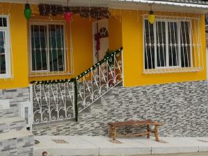 a yellow house with a bench in front of it at Casa Bella Vista in Buenavista