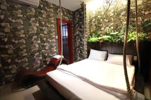 ホーチミン・シティにあるLoove Hotel - Khách Sạn Tình Yêuのベッドルーム1室(スイングベッド1台、植物付)