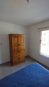 um quarto com uma cómoda de madeira e um tapete azul em El Roble, casa de sierra em Estancia Vieja