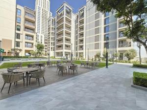 a courtyard with tables and chairs and buildings at Summer at Creek Beach - Vacationer in Dubai