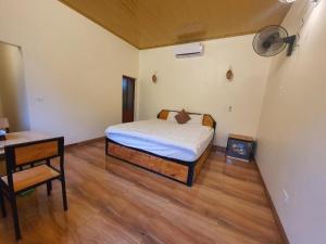 a bedroom with a bed and a table and a desk at Trang An Garden Bungalow Ninh Binh in Ninh Binh +25 photos