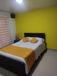 a bedroom with a large bed with yellow walls at Casa Bella Vista in Buenavista