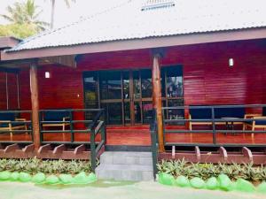 a red building with benches in front of it at Club Fiji Resort in Nadi