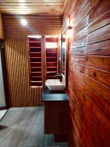 ein Badezimmer mit einem Waschbecken und einer Holzwand in der Unterkunft Club Fiji Resort in Nadi