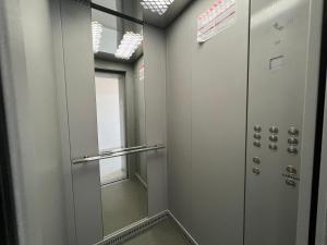 uma cabina de duche ao nível do chão num quarto com uma porta de vidro em Квартира SMART №5 em Pavlodar