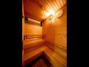 a wooden sauna with a light in the middle at Hotel Plus Hostel TOKYO ASAKUSA 1 in Tokyo