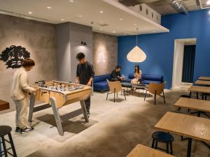 東京的住宿－Hotel Plus Hostel TOKYO ASAKUSA 1，一群人在房间里下棋