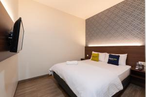 a bedroom with a bed and a flat screen tv at Urbanview Hotel Cengkareng Jakarta by RedDoorz in Jakarta