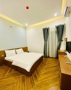 una camera con letto, scrivania e TV di Khách sạn Mimosa a Kon Plong