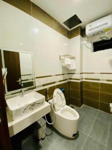bagno con servizi igienici bianchi e lavandino di Khách sạn Mimosa a Kon Plong