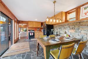 cocina con mesa de madera y pared de piedra en Cozy Cabin Getaway on Buffalo River with HUGE Patio, en Lobelville