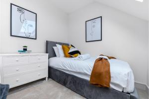 a bedroom with a bed and a white dresser at Creative stylings 2 Bedroom in Wembley Park in London