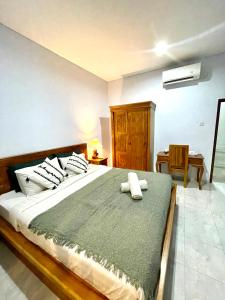 a bedroom with a large bed with two towels on it at Chua Guest house Canggu in Canggu