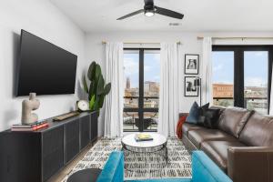 a living room with a couch and a flat screen tv at Premium Condo with Huge Patio near Vanderbilt & Downtown in Nashville