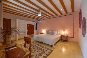 um quarto com uma cama, uma mesa e cadeiras em Casa Pakal Valladolid em Valladolid