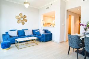 ein Wohnzimmer mit einem blauen Sofa und einem Tisch in der Unterkunft FIRST CLASS 1BR with DUBAI SKYLINE view in Dubai