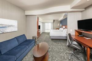 a living room with a blue couch and a bed at Courtyard by Marriott San Diego Oceanside in Oceanside