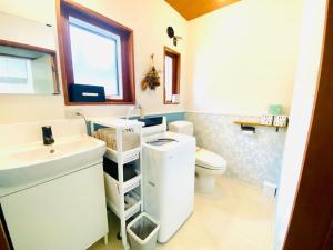 La salle de bains est pourvue d'un lavabo et de toilettes. dans l'établissement Pyrenees Cottage - Vacation STAY 24861v, à Hakuba
