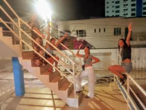 un grupo de mujeres de pie en una escalera por la noche en Makako Chillout Hostel, en Cartagena de Indias
