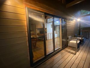 een afgeschermde veranda van een huis met ramen bij Pyrenees Cottage - Vacation STAY 24861v in Hakuba