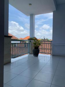 eine Veranda mit einer Topfpflanze auf dem Balkon in der Unterkunft Chua Guest house Canggu in Canggu