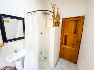a bathroom with a sink and a wooden door at Unicorn Reborn - Peaceful Rentals in San Marcos La Laguna