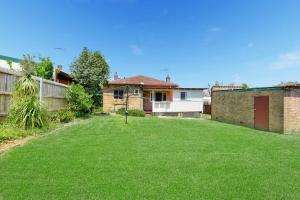 a yard with green grass in front of a house at Dream Vintage Place in Chatswood in Sydney