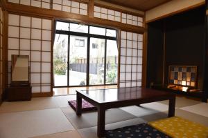 Cette chambre dispose d'une table et d'une grande fenêtre. dans l'établissement Kamekawa Yukari Ann, à Beppu