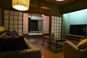 een woonkamer met een bank en een tafel bij Kamekawa Yukari Ann in Beppu