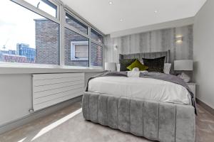 a bedroom with a large bed with a large window at 1 Bedroom stylish apartment in Webley park in London