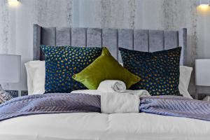 a bedroom with a large bed with colorful pillows at 1 Bedroom stylish apartment in Webley park in London