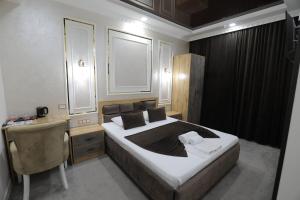 1 Schlafzimmer mit einem Bett und einem Schreibtisch sowie einem Bett der Marke sidx sidx sidx. in der Unterkunft Sharq hotel in Urganch