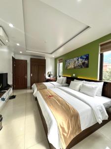 a large bedroom with two beds and a television at Phúc Lâm Hotel in Ha Giang