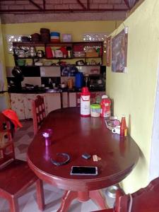 Cette chambre comprend une table en bois et une cuisine. dans l'établissement HOME of ELLAI, à Banga