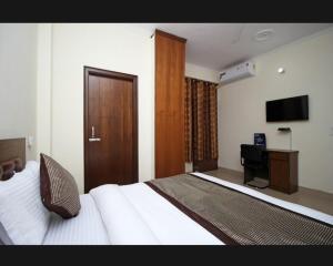 a hotel room with a bed and a television at Surya Stay Inn in New Delhi