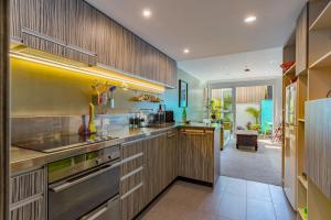 a kitchen with wooden cabinets and a counter top at Canvas Apartment in Wellington
