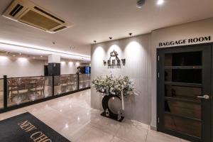 a lobby with a door and a vase of flowers at New Cheonji Hotel in Seoul