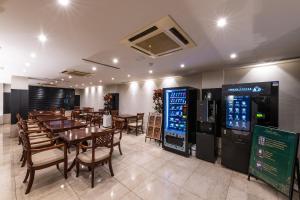un restaurant avec des tables et des chaises ainsi que des distributeurs automatiques dans l'établissement New Cheonji Hotel, à Séoul