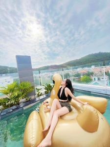 a woman is sitting on an inflatable at Nếp Apartment Hotel in Vung Tau