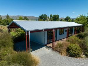 una pequeña casa con un techo de estaño en una colina en Musterers Accommodation Fairlie, en Fairlie