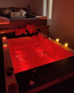 a red bath tub with hearts and candles in a bedroom at Nakupenda Relais 