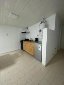 a kitchen with a white refrigerator and a tile floor at Amelie in General Roca