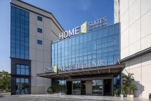 花都にあるHome2 Suites By Hilton Hotel Guangzhou Baiyun International Airport Branch - Free Shuttle Bus to Guangzhou Baiyun International Airport & Free Deliver Service to Canton Fair Complex During Canton Fair Periodの上に看板がある建物