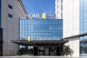 花都にあるHome2 Suites By Hilton Hotel Guangzhou Baiyun International Airport Branch - Free Shuttle Bus to Guangzhou Baiyun International Airport & Free Deliver Service to Canton Fair Complex During Canton Fair Periodのホームスイートのサインがある建物