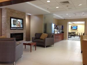 a waiting room with a couch and a fireplace at Holiday Inn Express Hotel & Suites West Chester, an IHG Hotel in West Chester