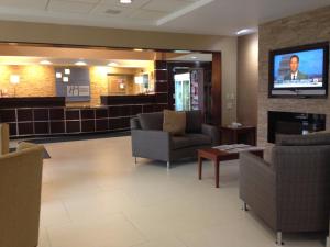 a waiting room with couches and a flat screen tv at Holiday Inn Express Hotel & Suites West Chester, an IHG Hotel in West Chester