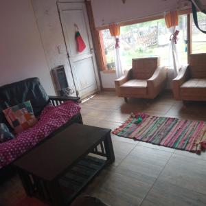 a living room with two couches and a table at Casa estilo cabaña in El Bolsón